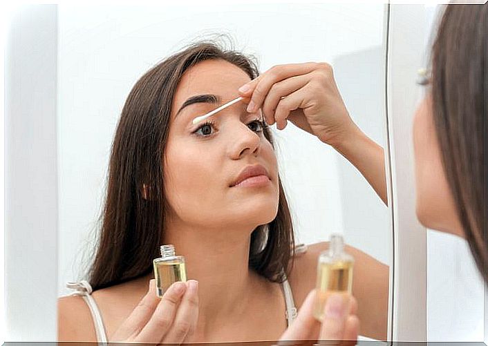 Woman cleaning her eyelashes with oils