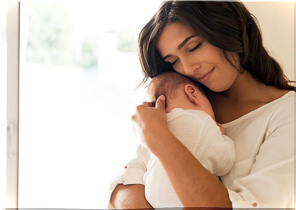 35 year old woman hugging her baby