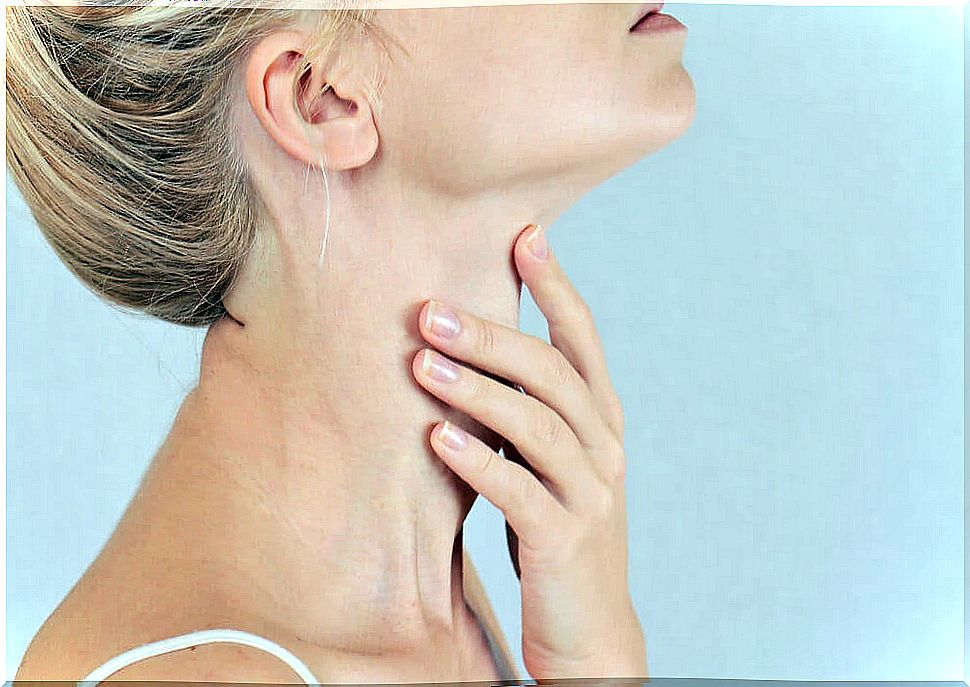 Girl touching her throat at the height of the thyroid.