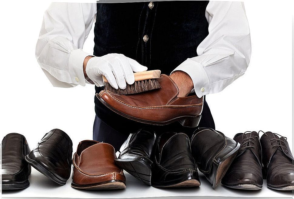 Person cleaning a set of leather shoes