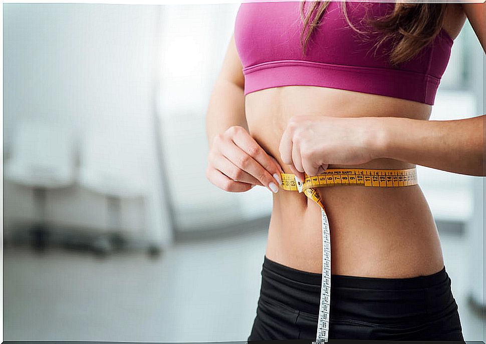 Woman measuring her abdomen.