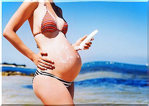 Pregnant applying sunscreen.