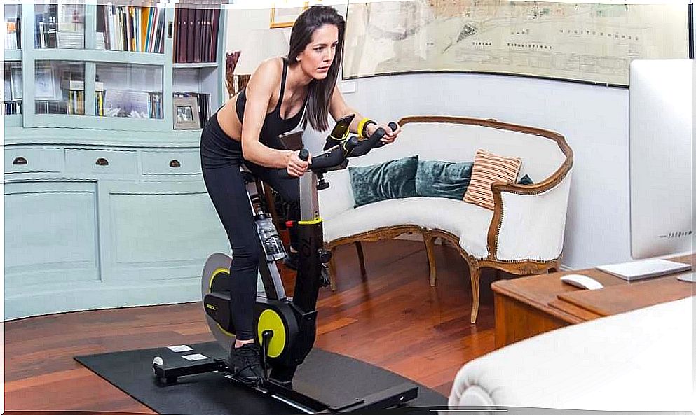 Woman doing exercise bike at home.