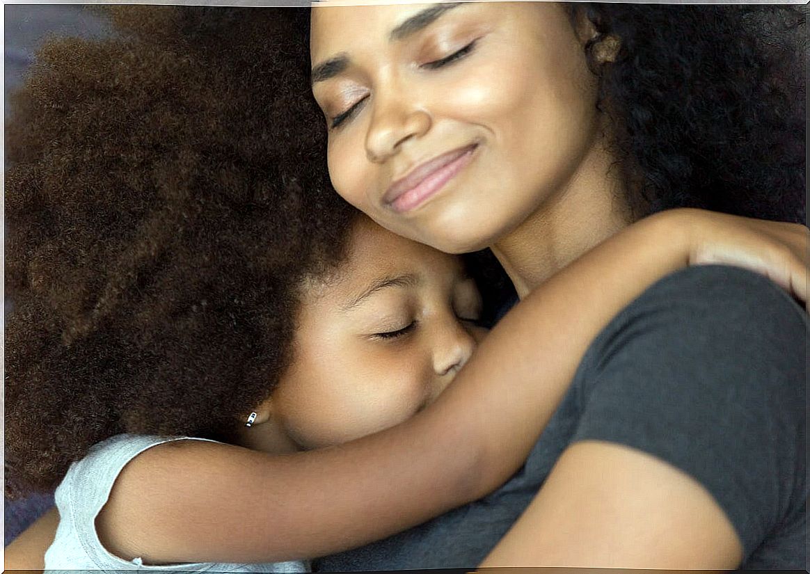 Mother hugs a little girl.